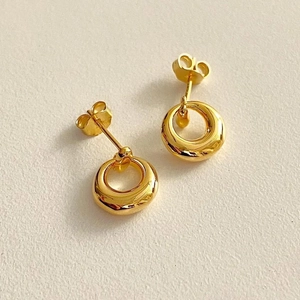 Macro shot of 925 sterling silver hollow round earrings with gold plating and butterfly back