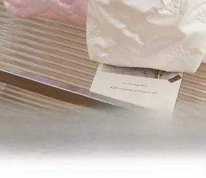 Close-up of quilted PU storage bag showing white and pink butterfly embossed textures