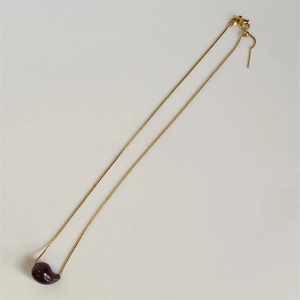 Detailed view of golden box chain with adjustable bead and smooth bean pendant necklace