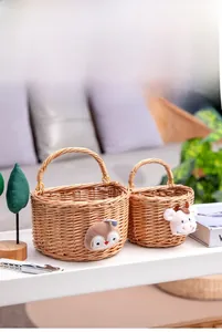 Detail of two handmade wicker storage baskets with penguin and cow plush decor