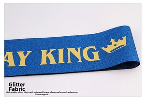 Gros plan sur l'écharpe d'anniversaire bleue pailletée avec lettrage KING doré et couronne