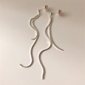 Detail view of long sterling silver snake chain drop earrings with minimalist wave texture