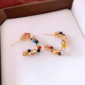 Vintage style gold C-shape twisted earrings with colorful agate beads in a jewelry box