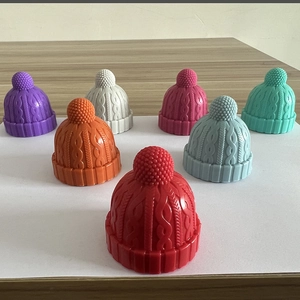 Close-up of knit-textured silicone wine stoppers in multiple colors on a wooden table