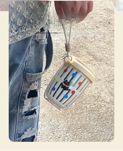 Detail of portable salad cup with woven lanyard showing cute cat and polka dot pattern