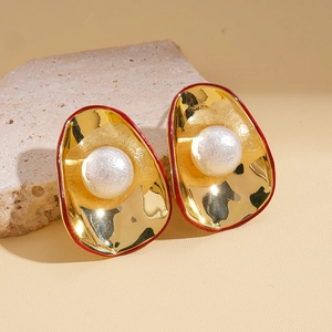 Détail de la boucle d'oreille vintage avec base dorée concave et perle d'imitation