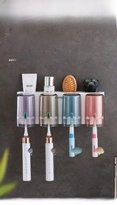 Wall-mounted toothbrush holder with four colorful cups and a top storage shelf for bathroom