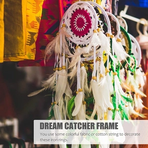 Detail of DIY dream catcher featuring white feathers and colorful woven net patterns