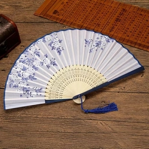 Classic Chinese folding fan with blue floral silk fabric and carved bamboo frame with tassel