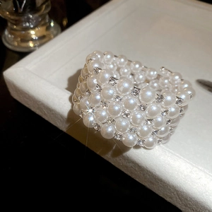 Close-up of luxury multi-layer pearl bracelet with sparkling diamonds on white display