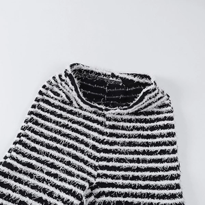 Gros plan d'un tissu en maille rayé noir et blanc avec franges et texture douce