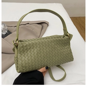Détail du sac en cuir tressé vert sauge avec finitions dorées et texture entrelacée