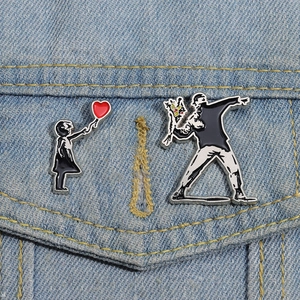 Banksy style graffiti art enamel pins set on denim jacket with red heart and flower motifs