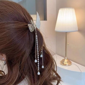 Detail of silver butterfly hair claw clip with crystal rhinestones and pearl tassels