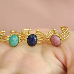 Three gold triple-line open rings featuring oval green, blue, and pink natural stones