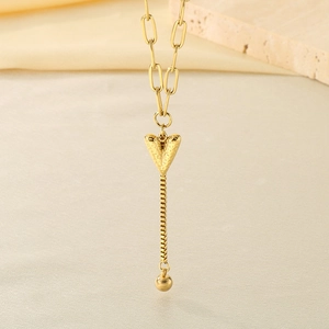 Gros plan détaillé d'un pendentif cœur martelé avec de longues franges en or