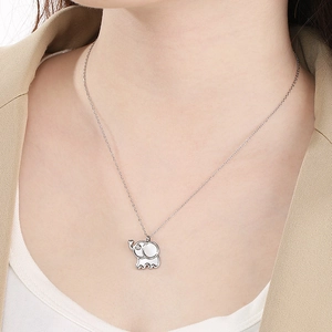 Close-up of a silver elephant pendant with shell inlay and small diamond accent