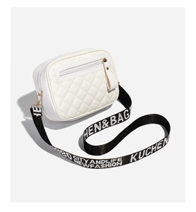 Detailed top view of white quilted crossbody bag with black printed strap and zipper pocket