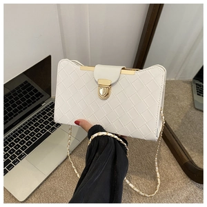Detailed view of a white woven shoulder bag with gold hardware and chain strap accents