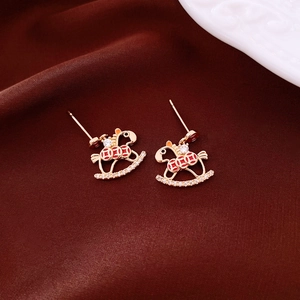 Detail of 18K gold plated rocking horse stud earrings with red enamel and pavé zircons