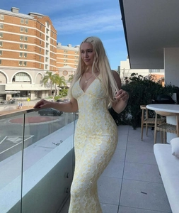 Detail of yellow and white floral lace texture on a V-neck slim fit vacation dress