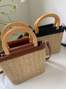 Detail of woven straw bucket bags featuring wooden handles and leather patchwork finish
