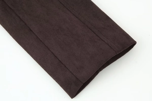Vue détaillée de la veste en daim marron foncé montrant les coutures et la texture