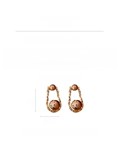 Close-up of gold geometric hoop earrings with copper material and silver pins details