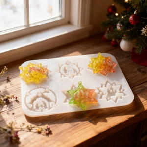 Detail of Christmas snowflake resin molds on a rustic wooden table with festive decor