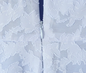 Detail shot of the back hidden zipper closure on light blue textured jacquard fabric