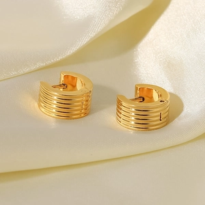 Chic 18K gold plated ribbed stainless steel hoop earrings on soft silk background