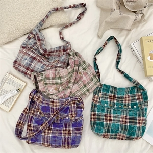 Vue à plat de sacs en toile à carreaux tie-dye en quatre couleurs avec rabat et boucles