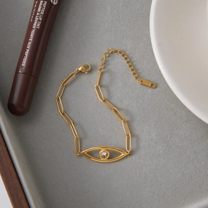 Detail of 18K gold stainless steel evil eye bracelet with crystal inlay on a tray