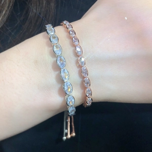 Detail of adjustable tennis bracelets with oval-cut cubic zirconia in silver and rose gold