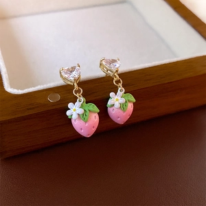 Pink strawberry earrings with heart zircon and floral detail on a vintage jewelry box