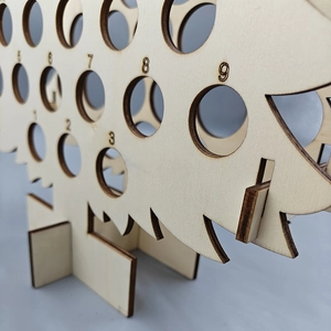 Macro detail of wooden Christmas tree countdown calendar with numbered circular cutouts