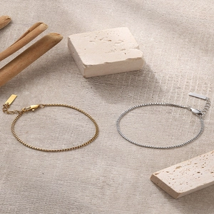 Minimalist stainless steel box chain bracelets in gold and silver on natural stone
