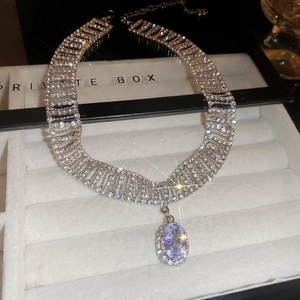 Gros plan détaillé du collier en argent avec pierre violette dans un coffret