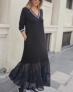 Détail du col en V rayé et de l'ourlet en tulle plissé sur une robe mi-longue noire
