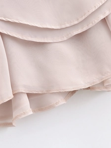 Detailed close-up of layered pink chiffon ruffles with high-quality stitching on a dress