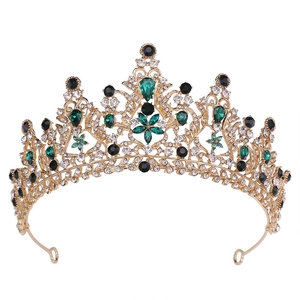Detailed macro of golden bridal crown featuring green teardrop crystals and rhinestones