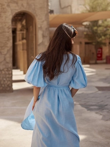 Detail eines hellblauen Baumwollkleids mit Puffärmeln und Taillenband im Urlaubsstil