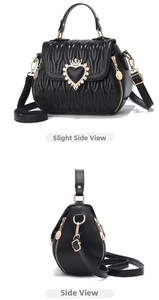 Detail view of black pleated bucket bag with gold heart crown buckle and side zipper