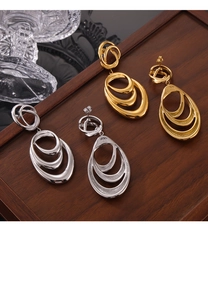 Close-up of gold and silver layered irregular loop earrings on a wooden tray