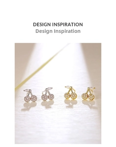 Detailed macro view of cherry stud earrings with zircon inlay in gold and silver finish