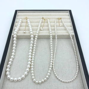 Detailed view of three pearl necklaces with gold plated clasps in varying sizes