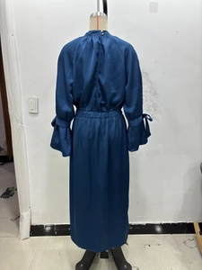 Detail of satin midi dress featuring elastic waist and bow-tie cuffs in blue