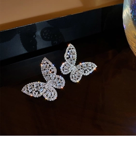 Detailed view of silver butterfly earrings with sparkling cubic zirconia on dark surface