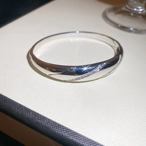 Macro detail of silver bangle featuring cubic zirconia inlay and starry light reflection