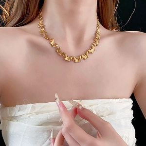 Close-up of golden butterfly pendant necklace worn by a model for a stylish look